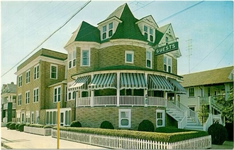 A multi-story brick hotel with a tower, green roof, awnings, and a 
