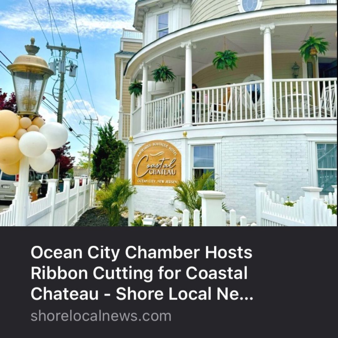 Ribbon-cutting at the Coastal Chateau in Ocean City, with balloons, a white fence, and a building with a veranda.