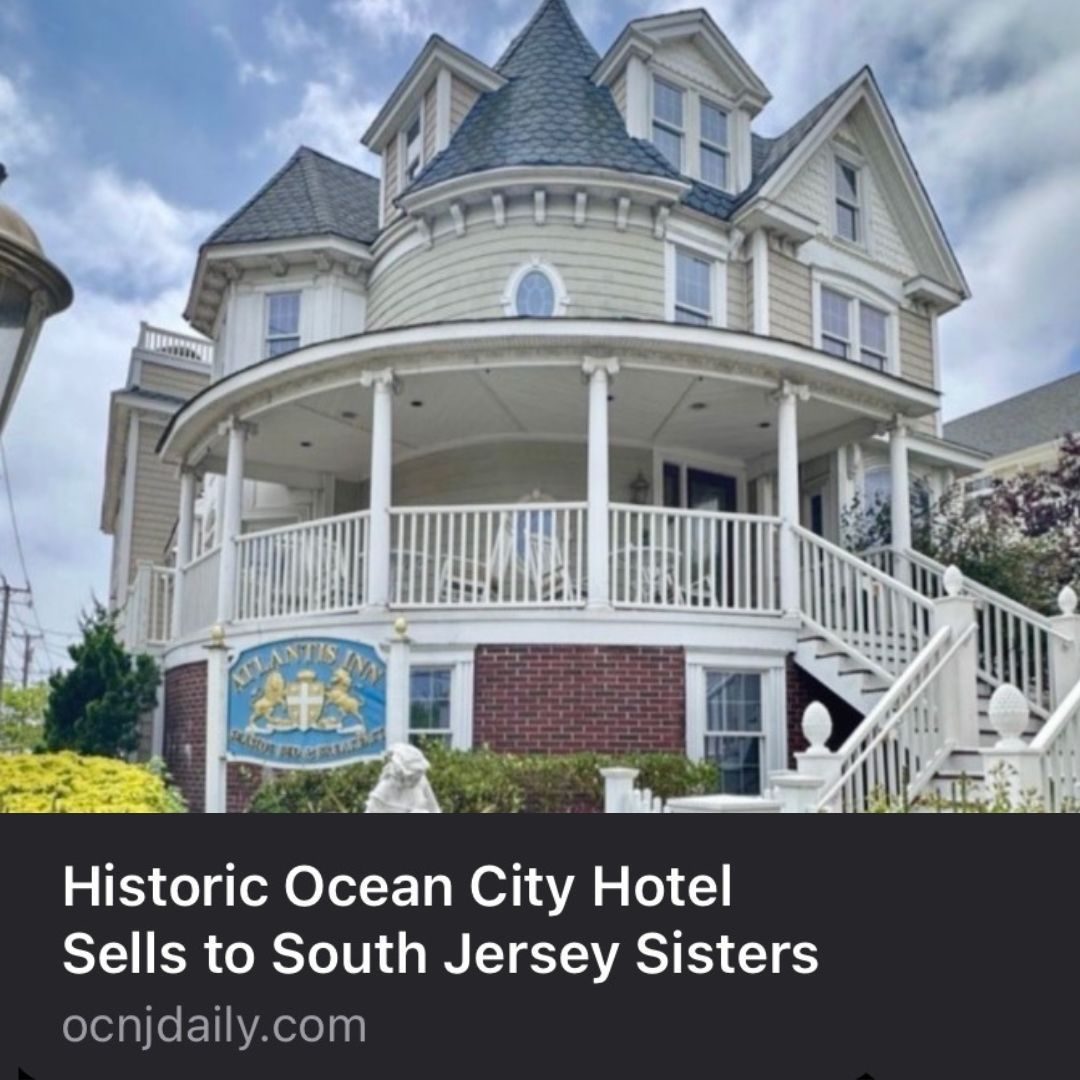 Historic Ocean City hotel with a wrap-around porch and a sign that reads