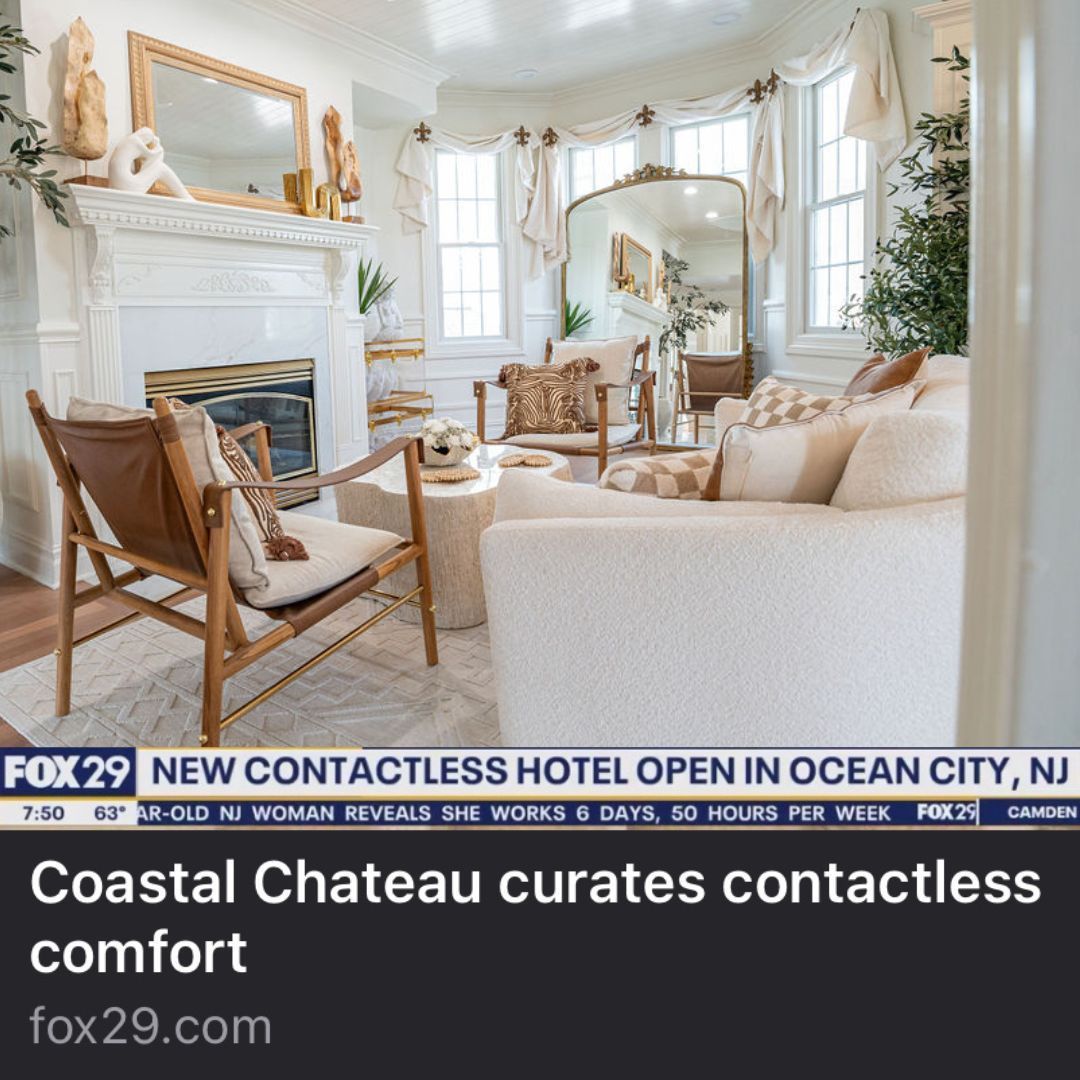 Living room with white sofa, fireplace, and window; promoting a contactless hotel in Ocean City, NJ.