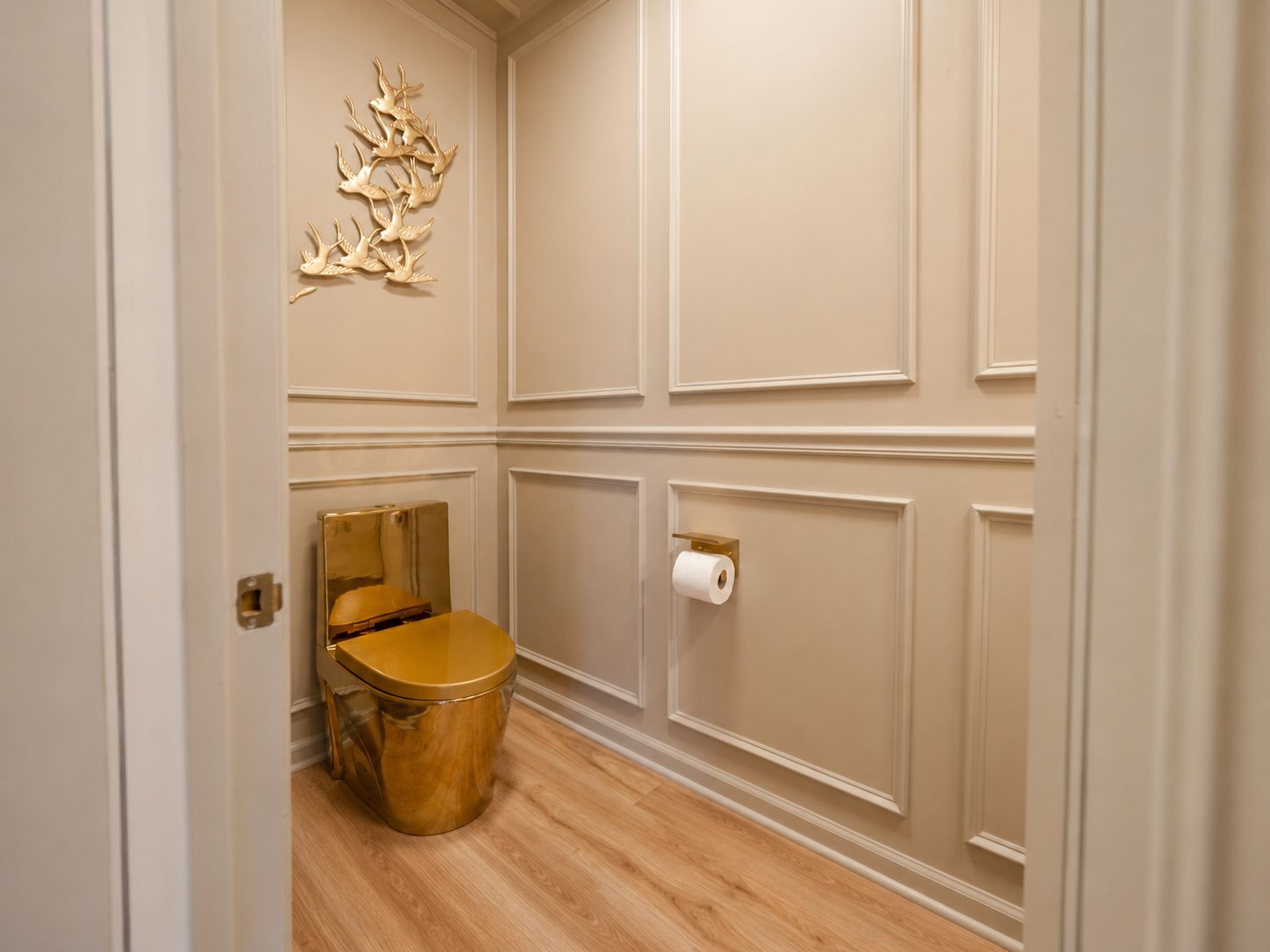 Elegant bathroom with gold toilet and matching decor in a beige paneled room