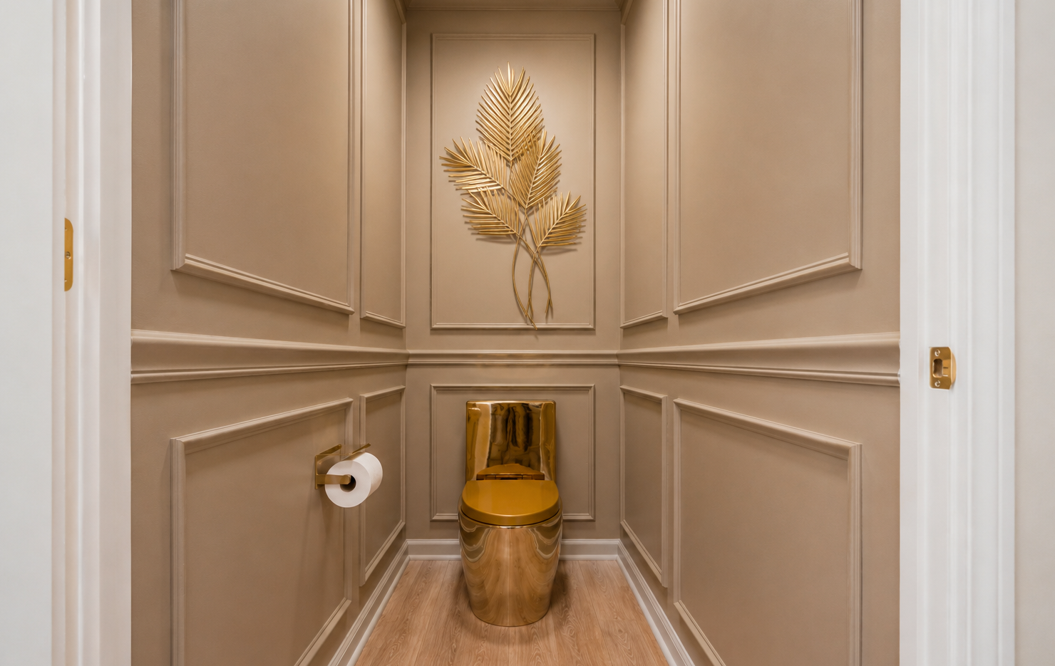 Elegant beige powder room with gold toilet, wall art, and toilet paper holder.
