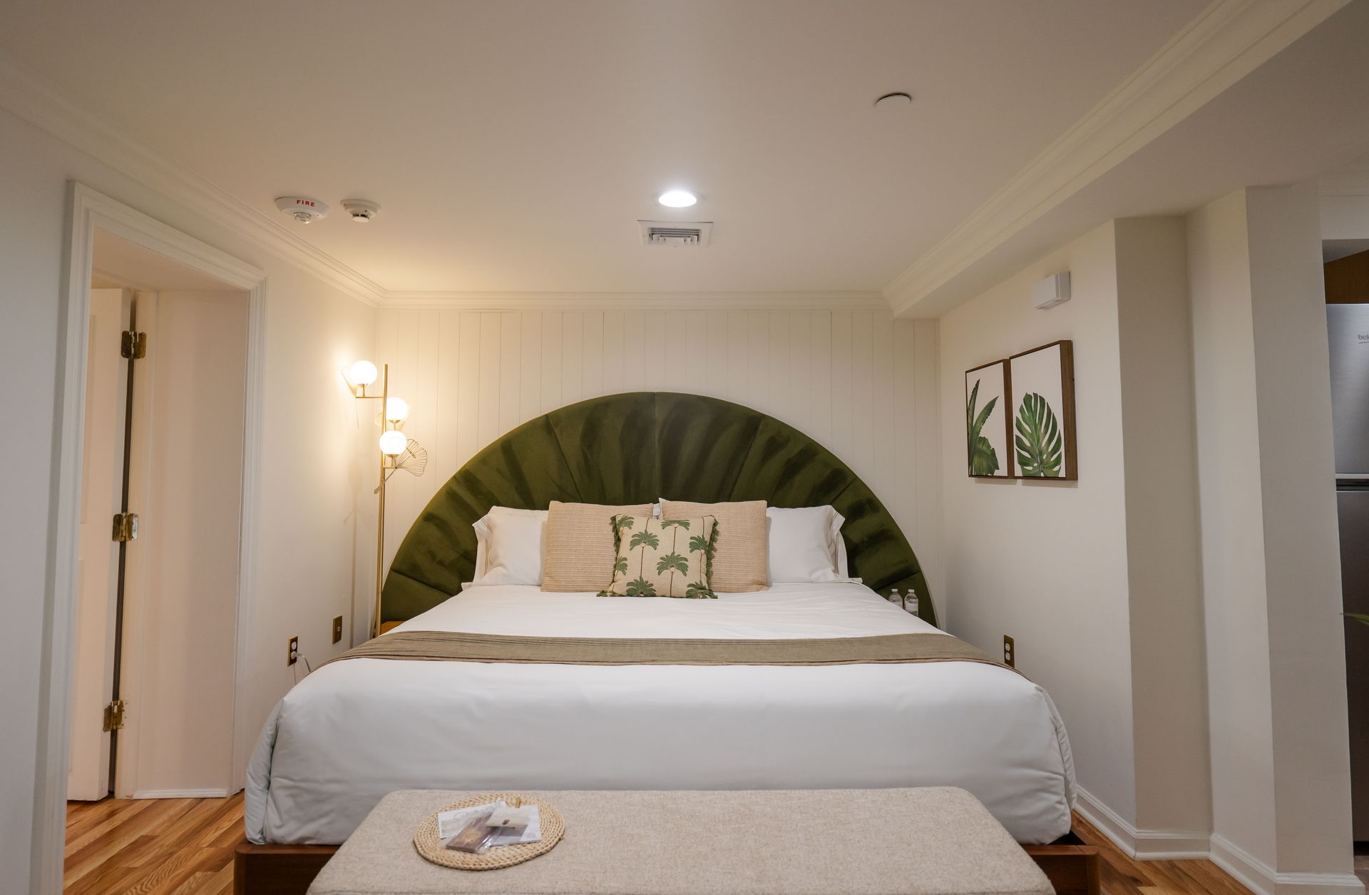 Bedroom with large bed, green headboard, and decorative pillows.