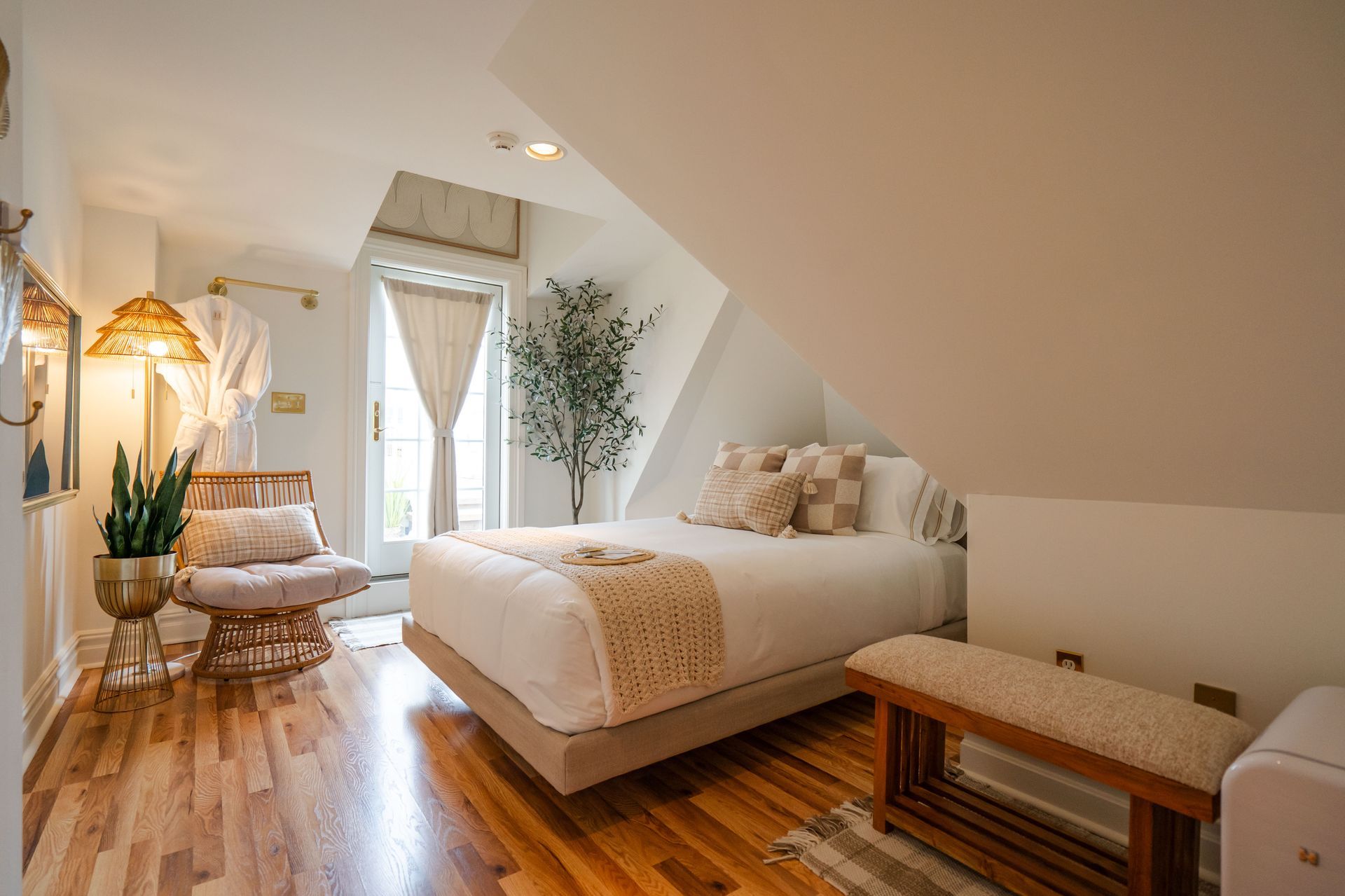 Bedroom with hardwood floors, a bed, a chair, and a window.