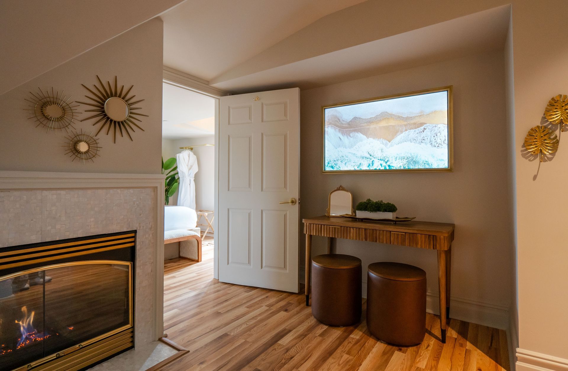 Cozy room interior with fireplace, TV, wooden console table, and door leading to a bedroom.