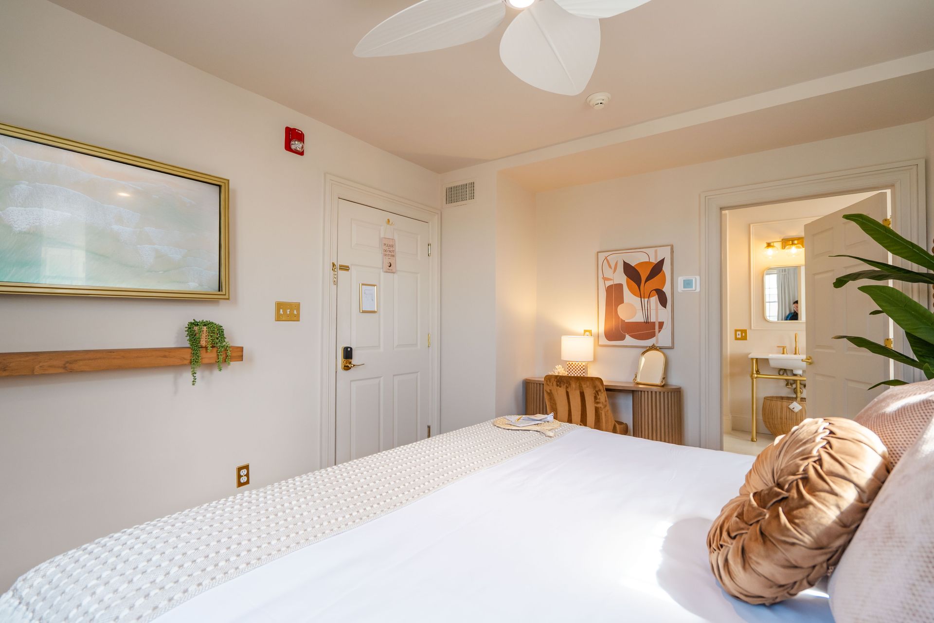 Bedroom with a white bed, white walls, and a doorway to a bathroom.