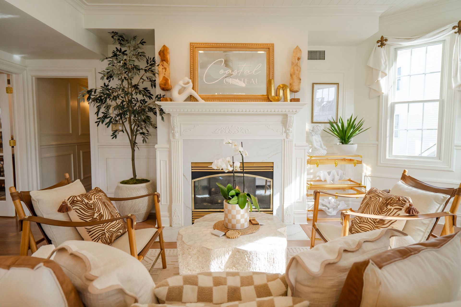 Cozy living room with fireplace, wood chairs, cream and gold decor.