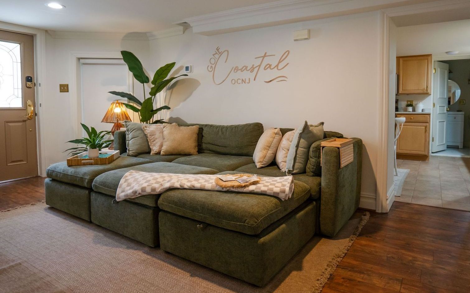 Cozy living room with green sectional sofa, neutral pillows, and 