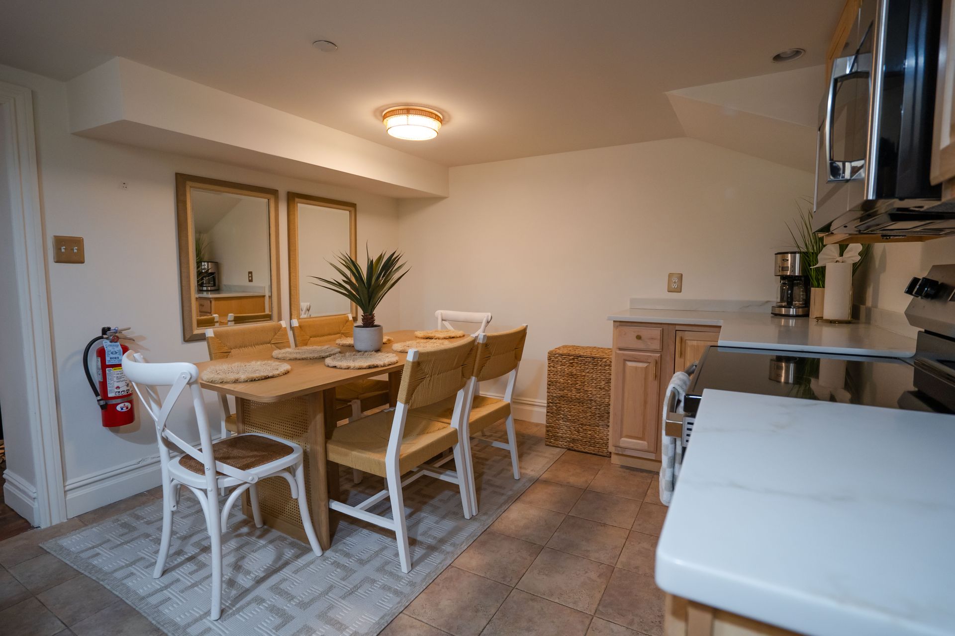 Dining area with table, chairs, and kitchen appliances. Beige and white color scheme.