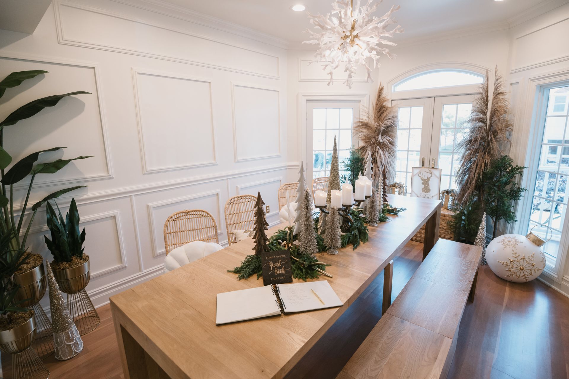 Elegant dining room with decorated Christmas table and large chandelier.