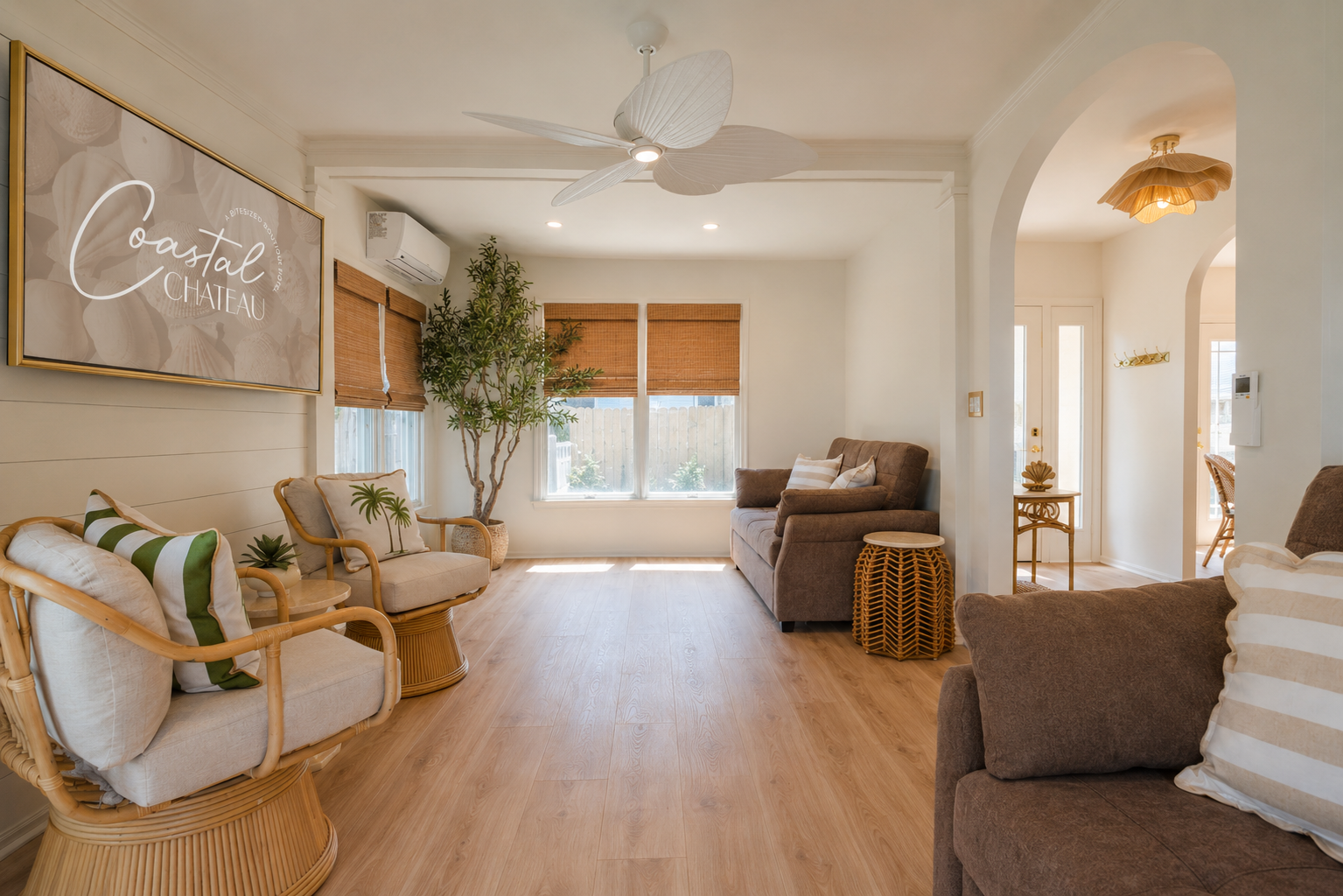 Bright living room with beige sofas, wood floors, plants, and arched doorway in a modern home