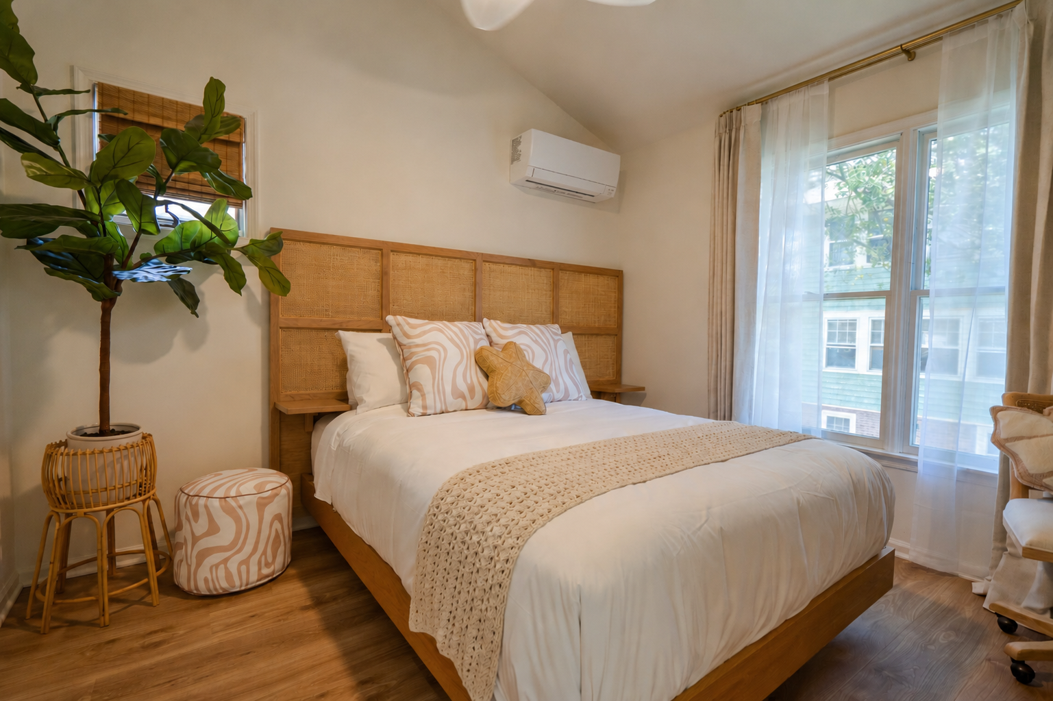 Cozy bedroom with a wooden bed, cream decor, plants, and a window with sheer curtains