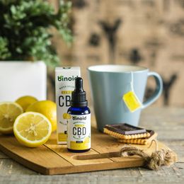 A bottle of cbd is sitting on a wooden cutting board