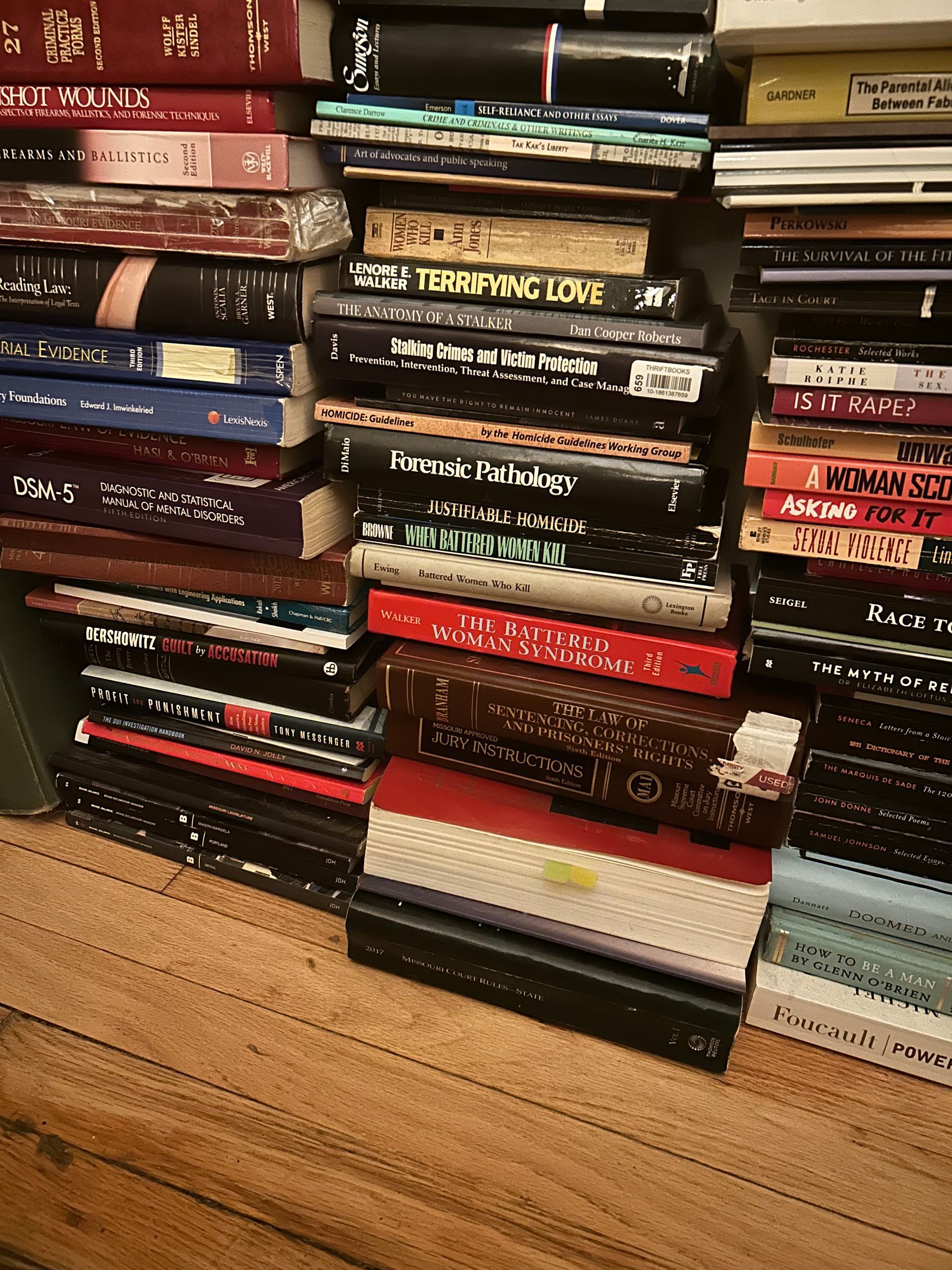 A stack of books on a wooden shelf including one titled ' a thousand years of love '