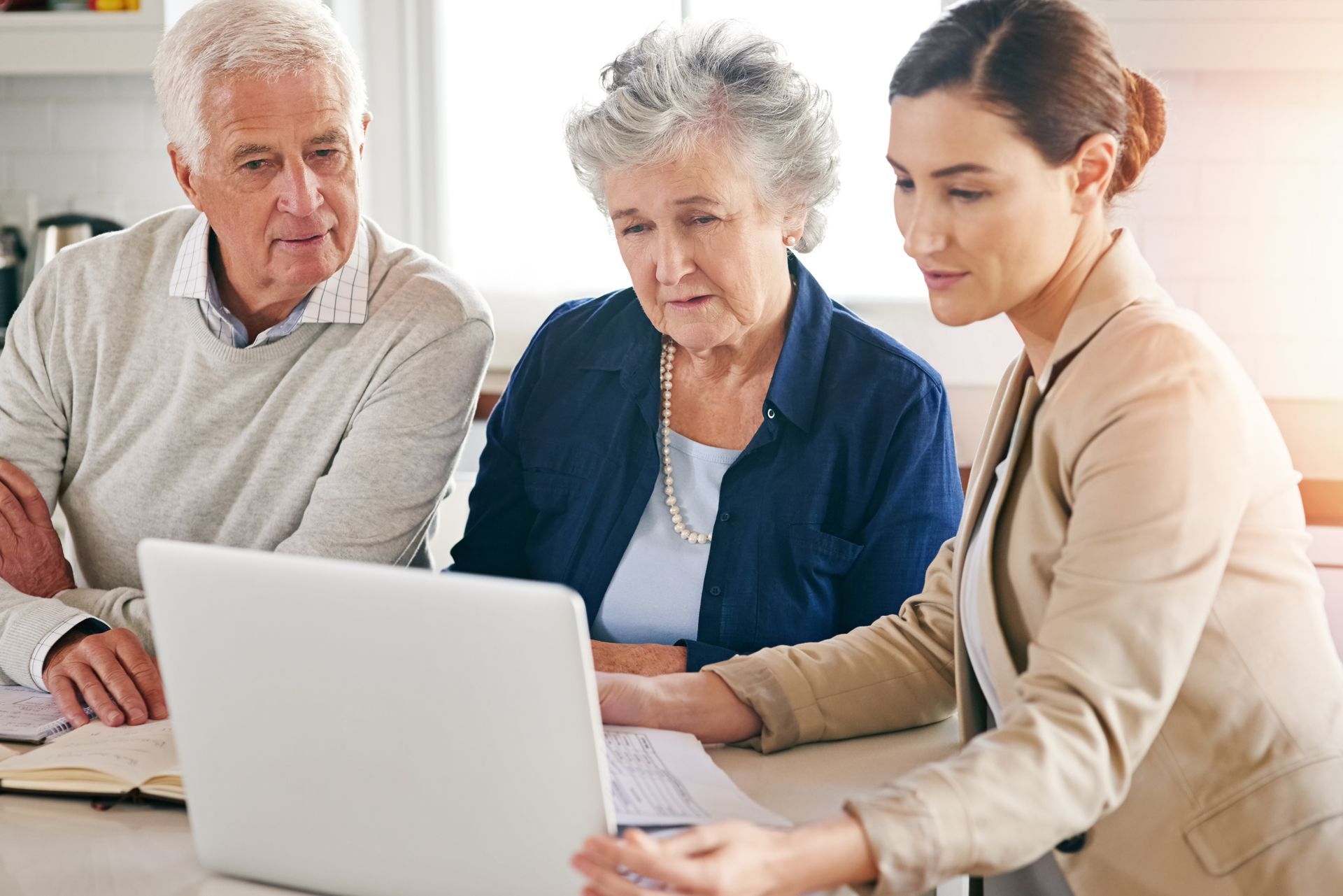 A senior couple and lawyer in consultation with a laptop in their retirement village.