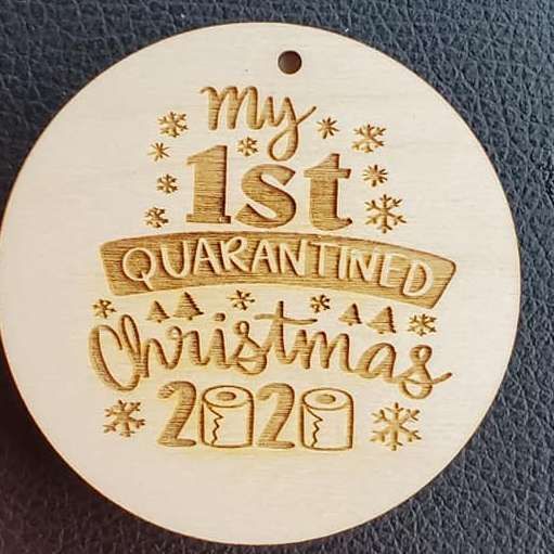 Wooden round ornament engraved “My 1st Quarantined Christmas 2020” with snowflakes and stars.
