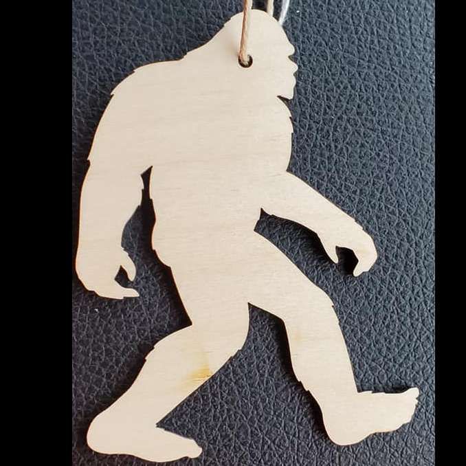Wooden Bigfoot silhouette pendant on a black textured background