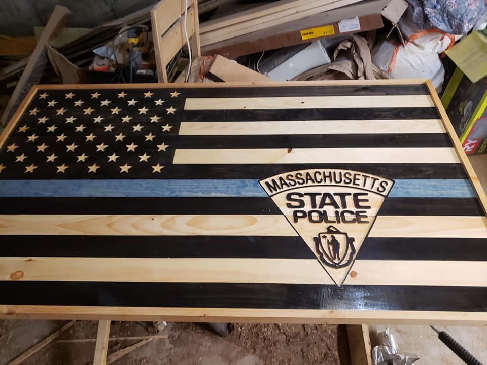Handmade American flag with Massachusetts State Police emblem on a wooden table