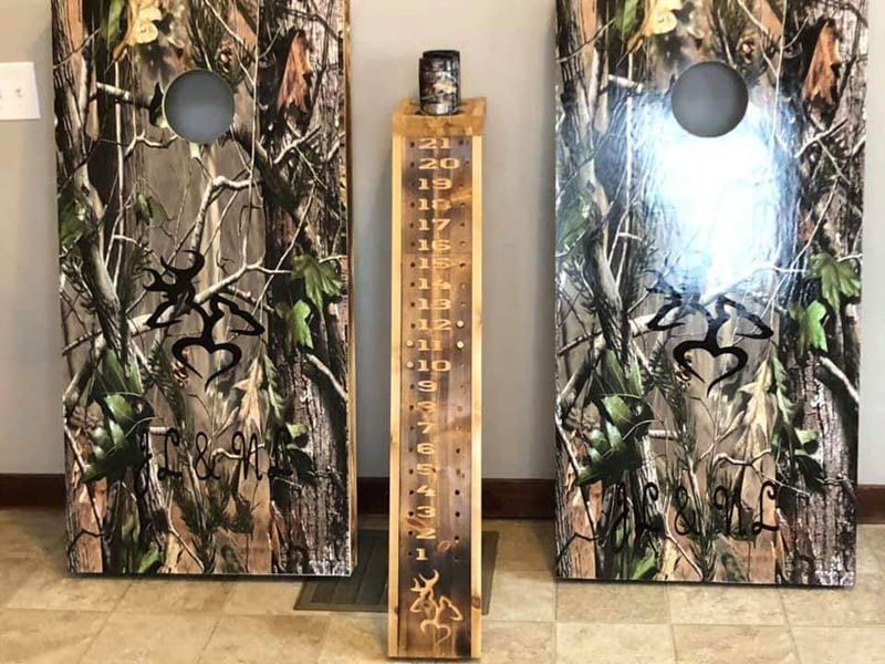 Two camouflage-patterned speaker cabinets flank a tall wooden pendulum-style thermometer.