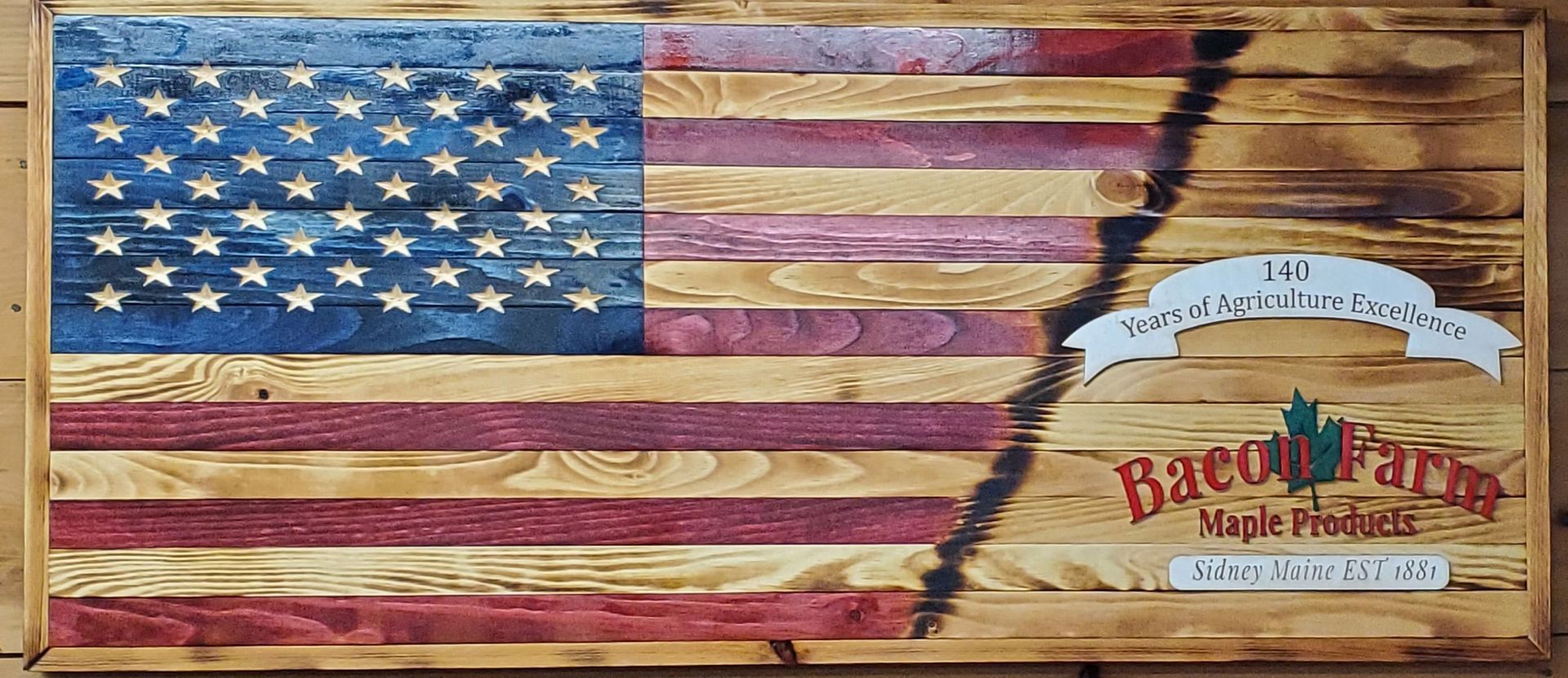American flag painted on wood beside the Big Dutch Farm Maple Products logo