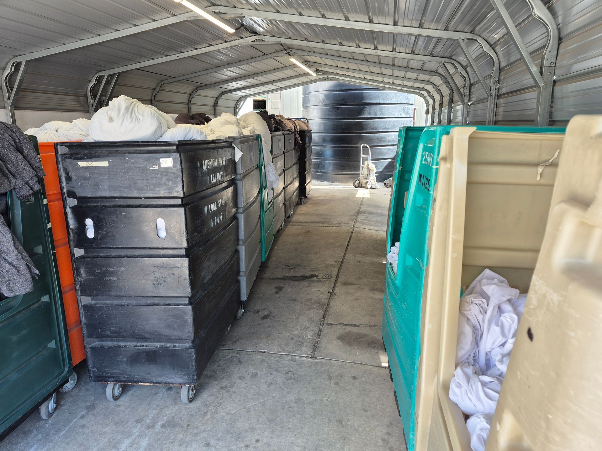 Orange and blue plastic bins stacked in a storage area.