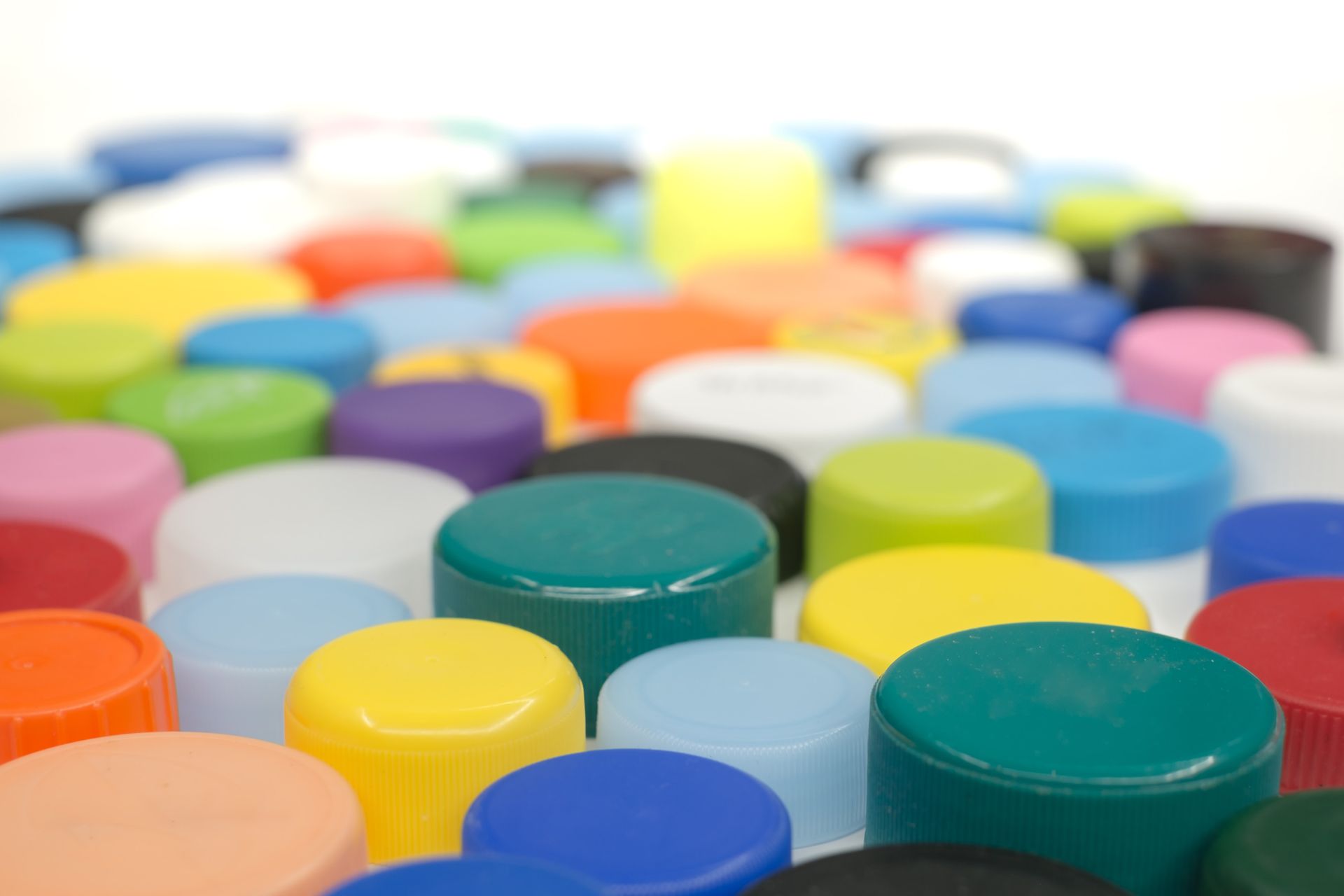 A bunch of colorful plastic bottle caps on a table