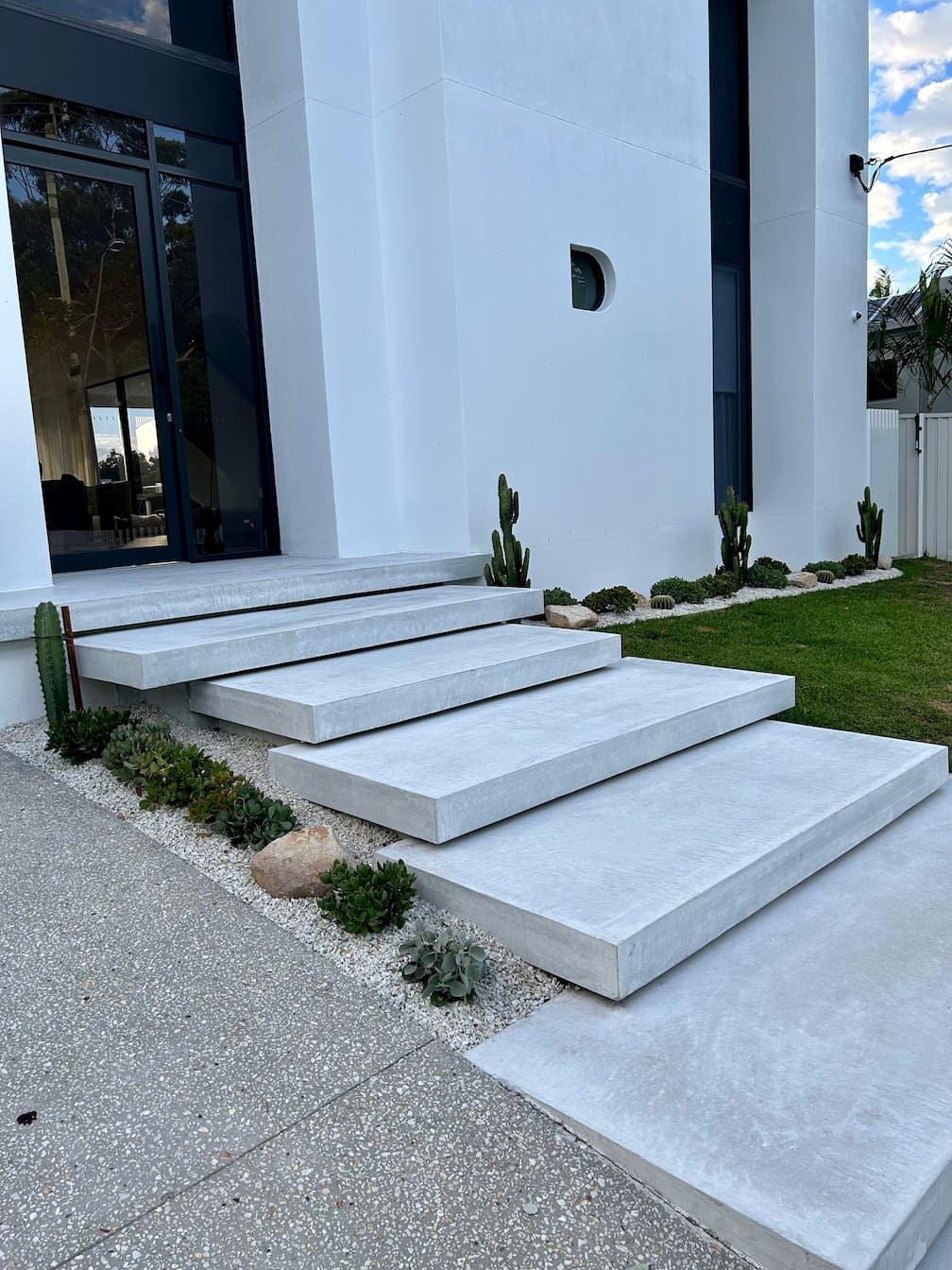 a set of concrete steps leading up to a white building