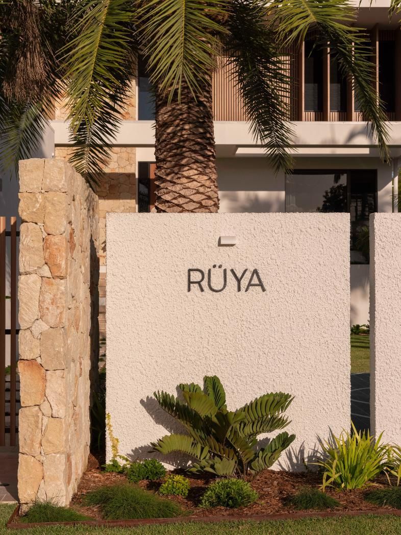 A modern, textured concrete wall displaying the name