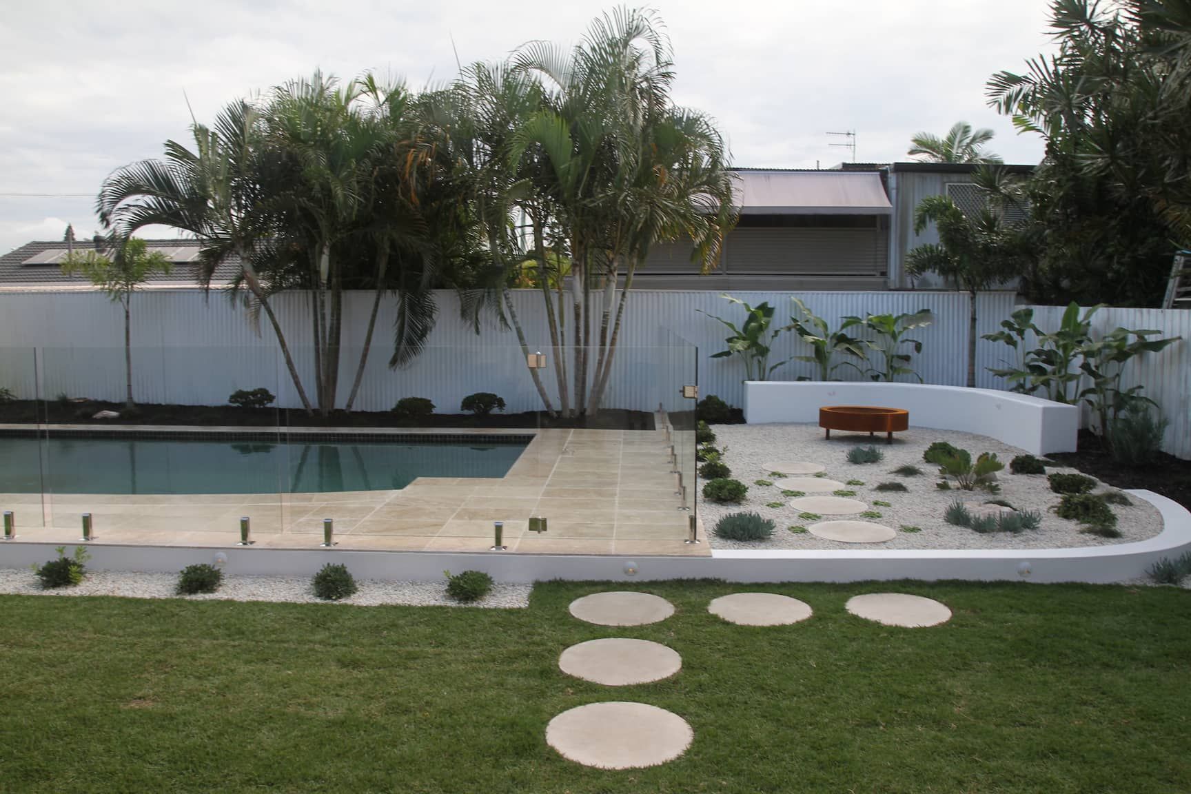 a backyard with a swimming pool and a fire pit