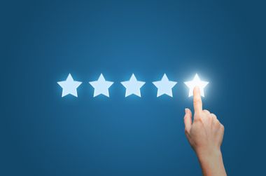 A hand is pointing at a star in the middle of a row of stars.