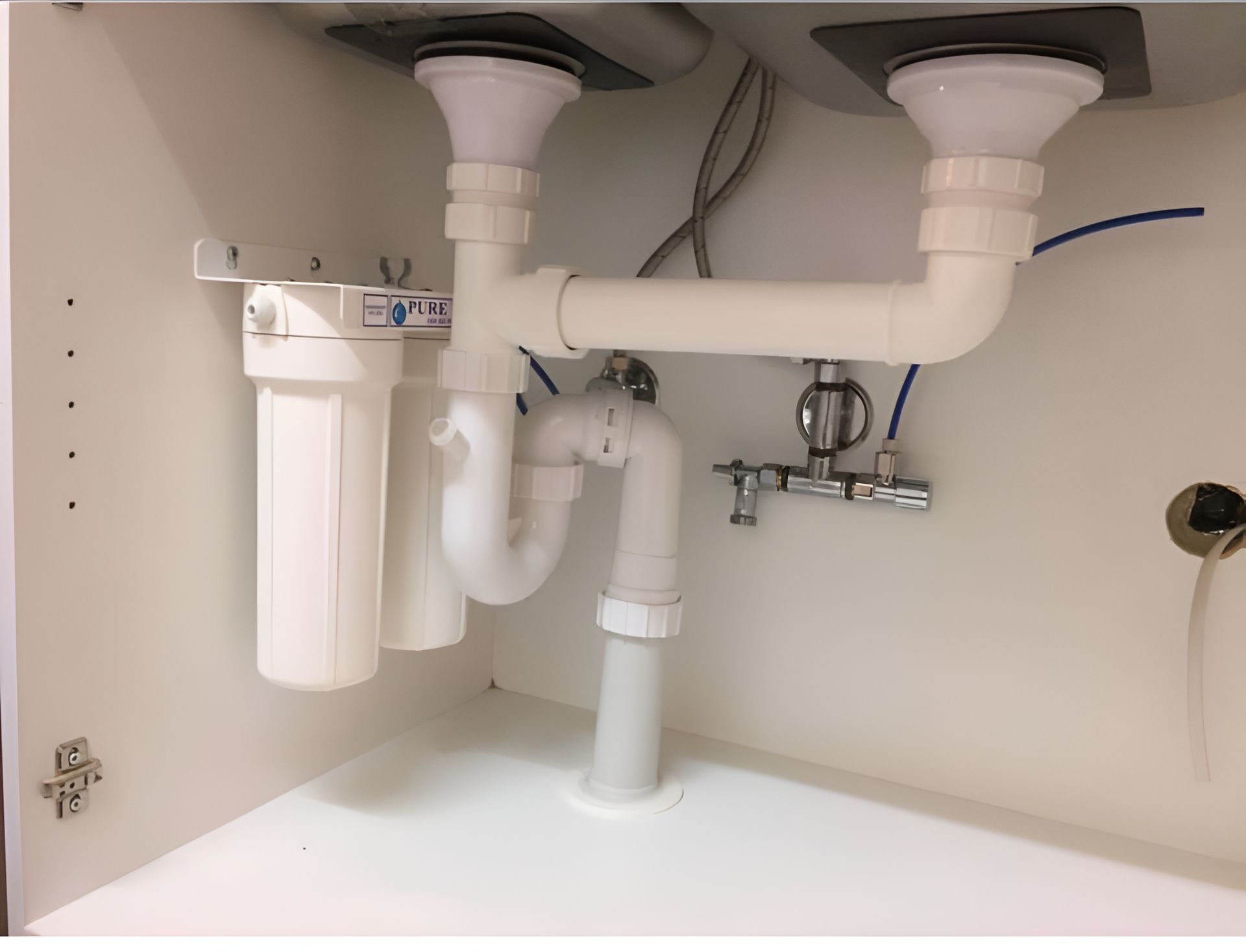 The Underside Of A Kitchen Sink With A Faucet And Pipes — Casino Plumbing In Casino, NSW