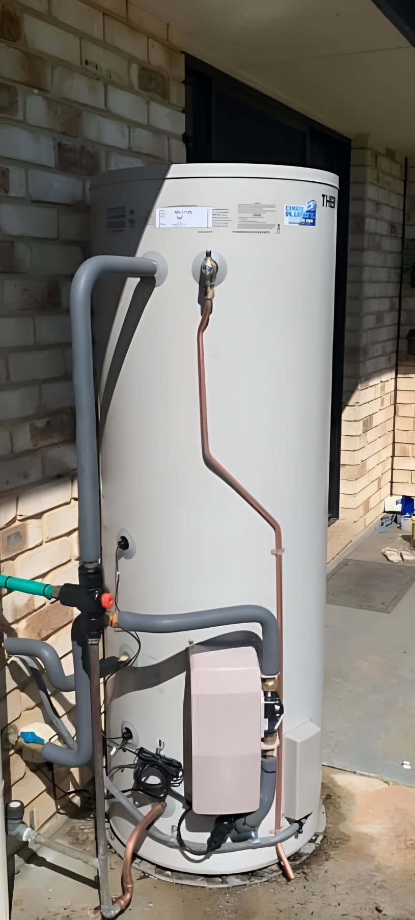 A Water Heater Is Sitting Outside Of A Brick Building — Casino Plumbing In Casino, NSW