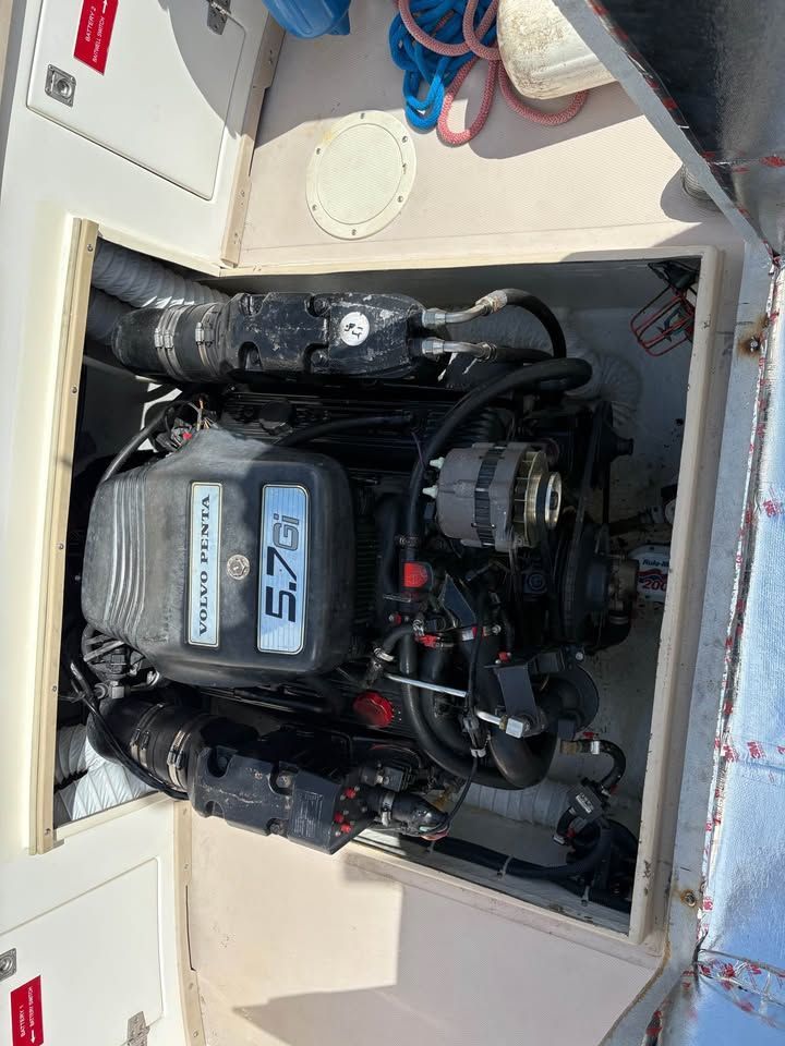 Open engine compartment with a black and silver 5.7 MerCruiser marine engine.