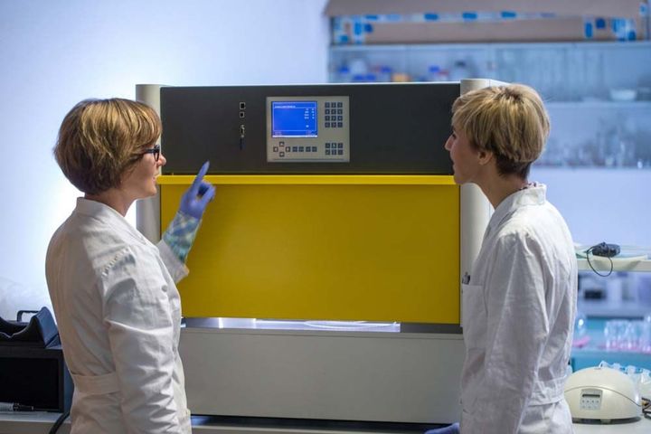 Women in white coats in a lab. Women in white coats in a lab.