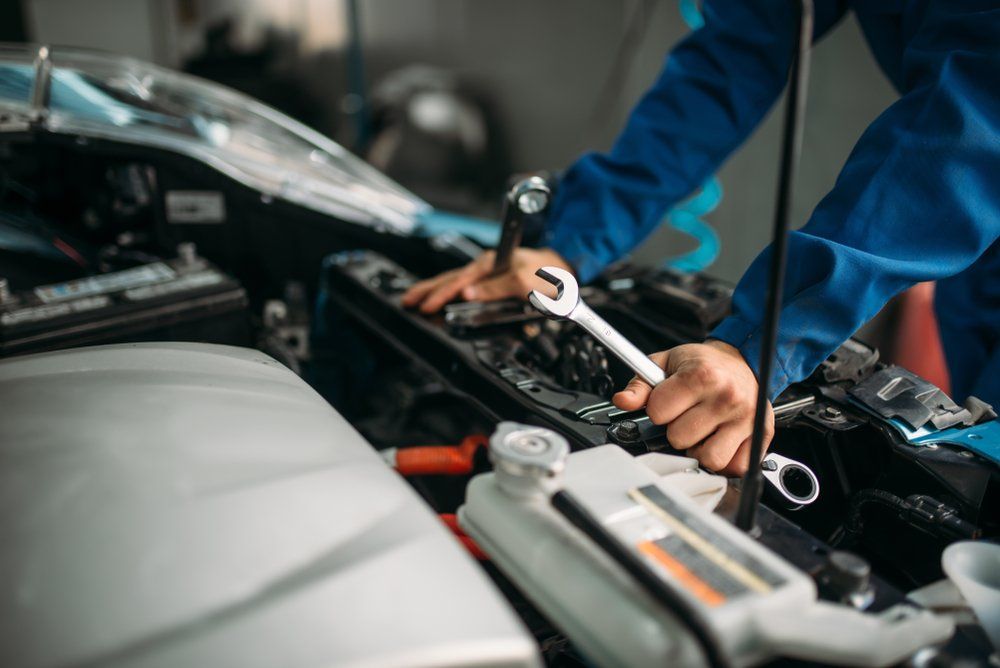 A Man Is Working on The Engine of A Car with A Wrench — Modern Motors-Nabiac in Nabiac, NSW