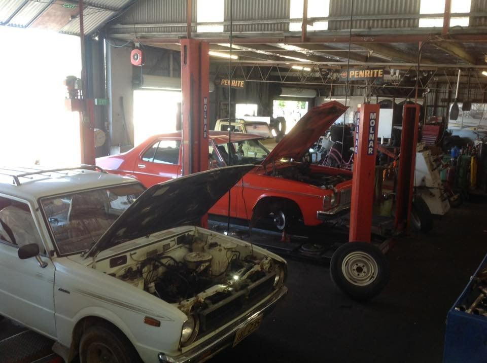A White Car with Its Hood Open Is in A Garage with Other Cars — Modern Motors-Nabiac in Nabiac, NSW