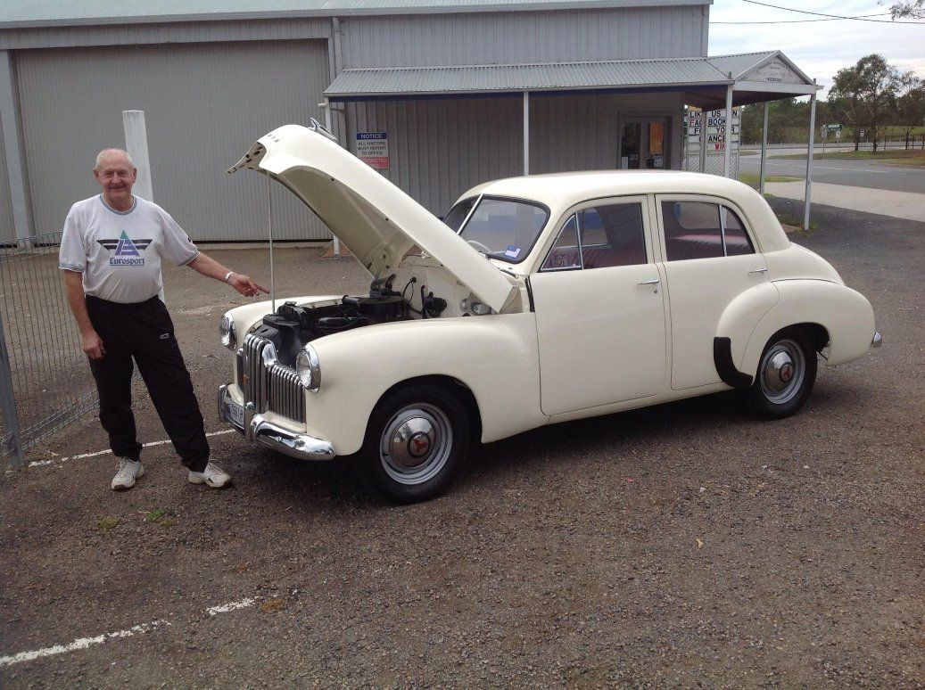 A Man Is Standing Next to A White Car with The Hood Open — Modern Motors-Nabiac in Nabiac, NSW