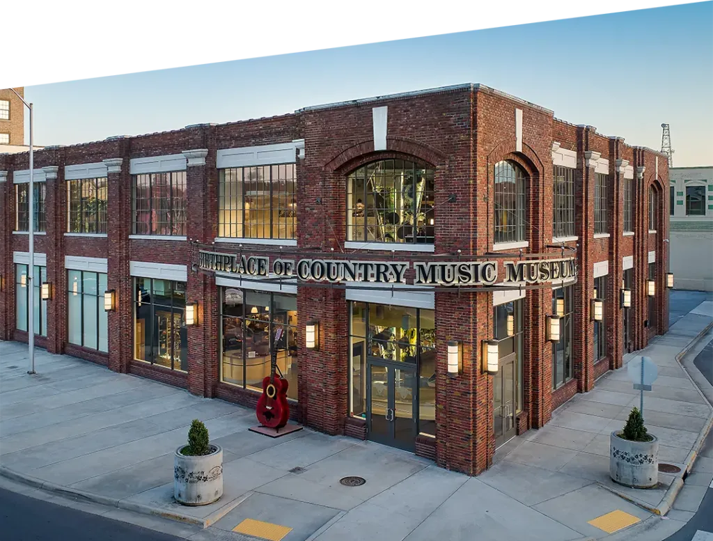 Red brick museum building with large windows and “MUSEUM” sign on a city street corner