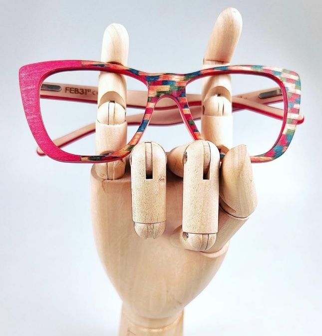 Feb31st eyewear glasses custom painted by Janet B. Sessoms propped on wooden hand 