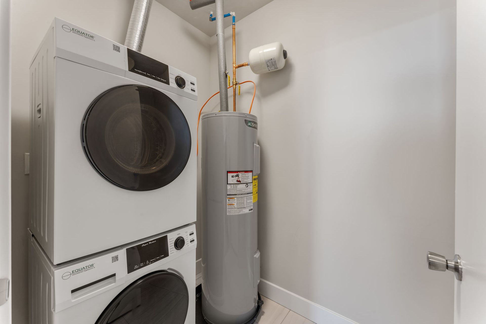 A laundry room with a washer and dryer and a water heater.