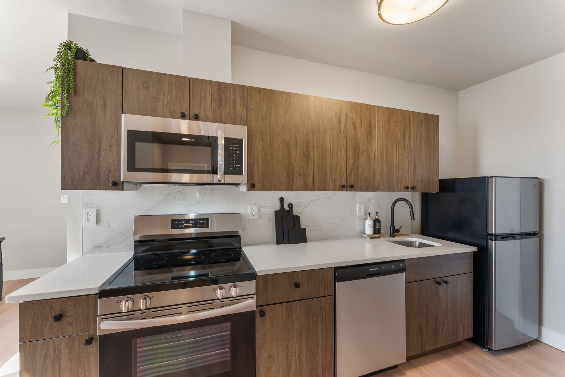 A kitchen with stainless steel appliances and wooden cabinets