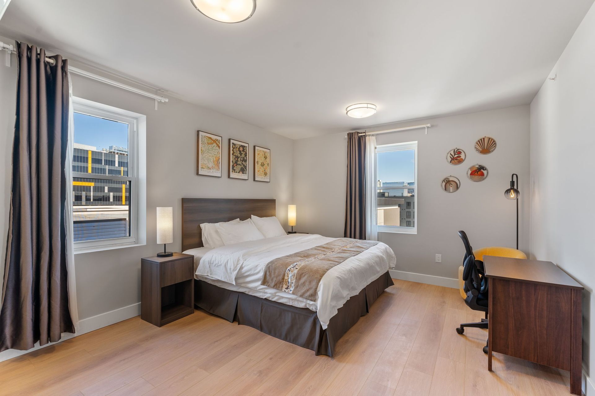 A bedroom with white sheets and orange pillows