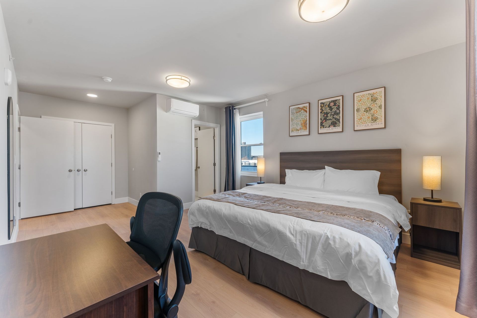 A bedroom with a large bed and a desk