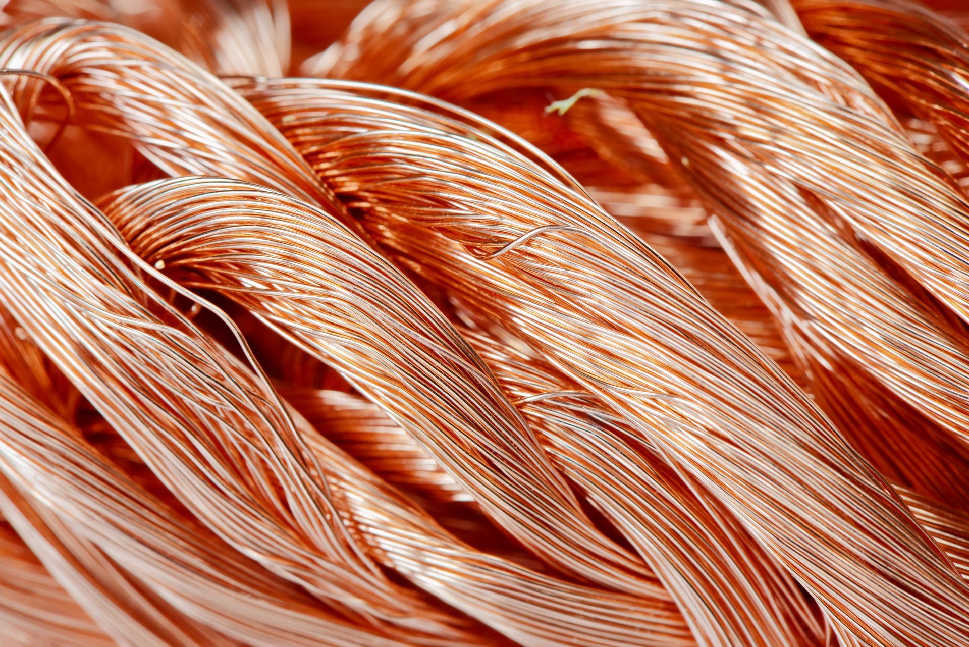 Close-up of coiled copper wires showing bright metallic texture, fine strands. Close-up of coiled copper wires showing bright metallic texture, fine strands.