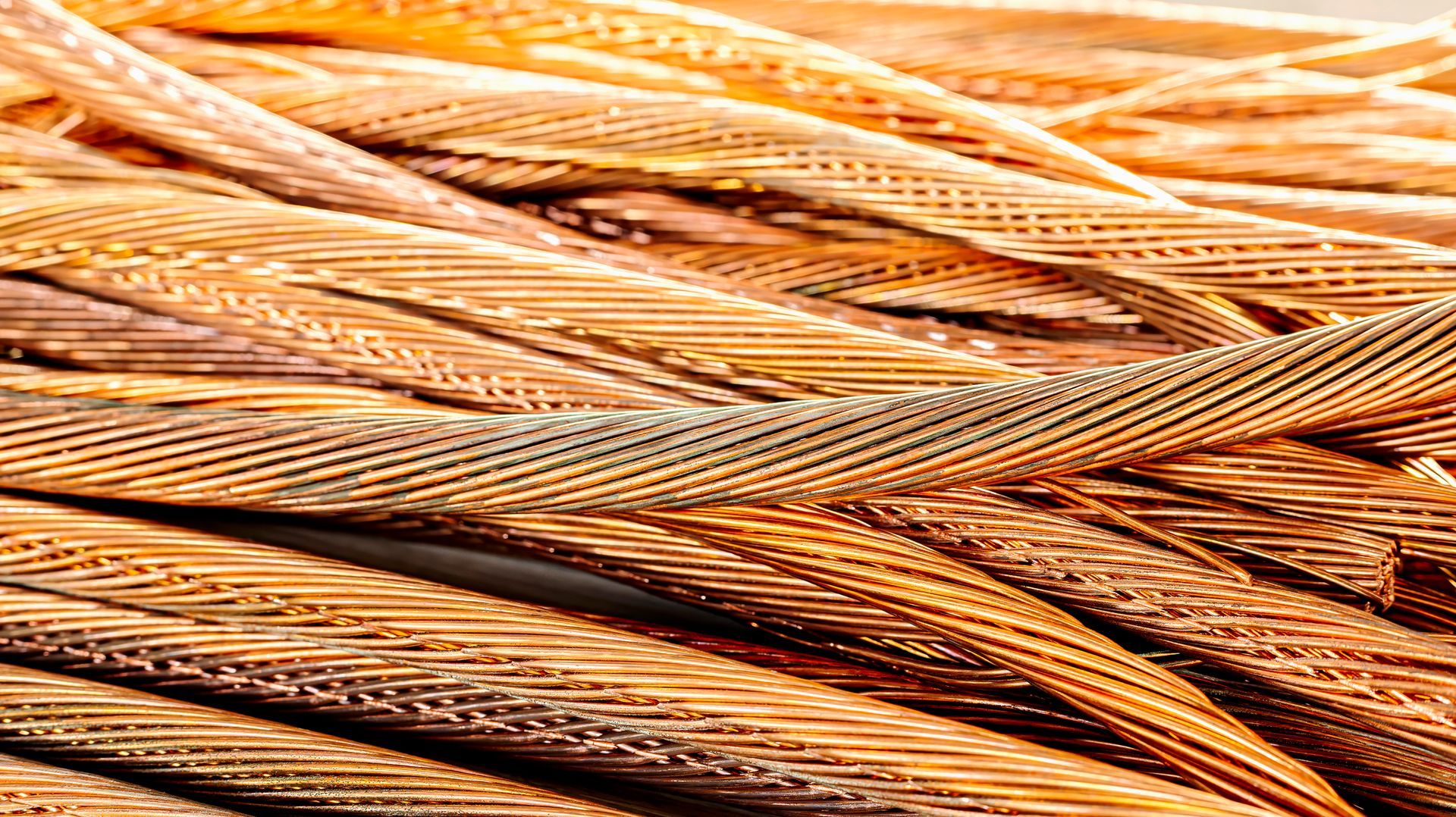 Close-up of a tangled bundle of copper wires, showing their twisted strands and metallic orange color.