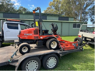 Orange Lawn Mower Getting Towed on Trailer — Michael Flick Horticulture in Coffs Harbour, NSW