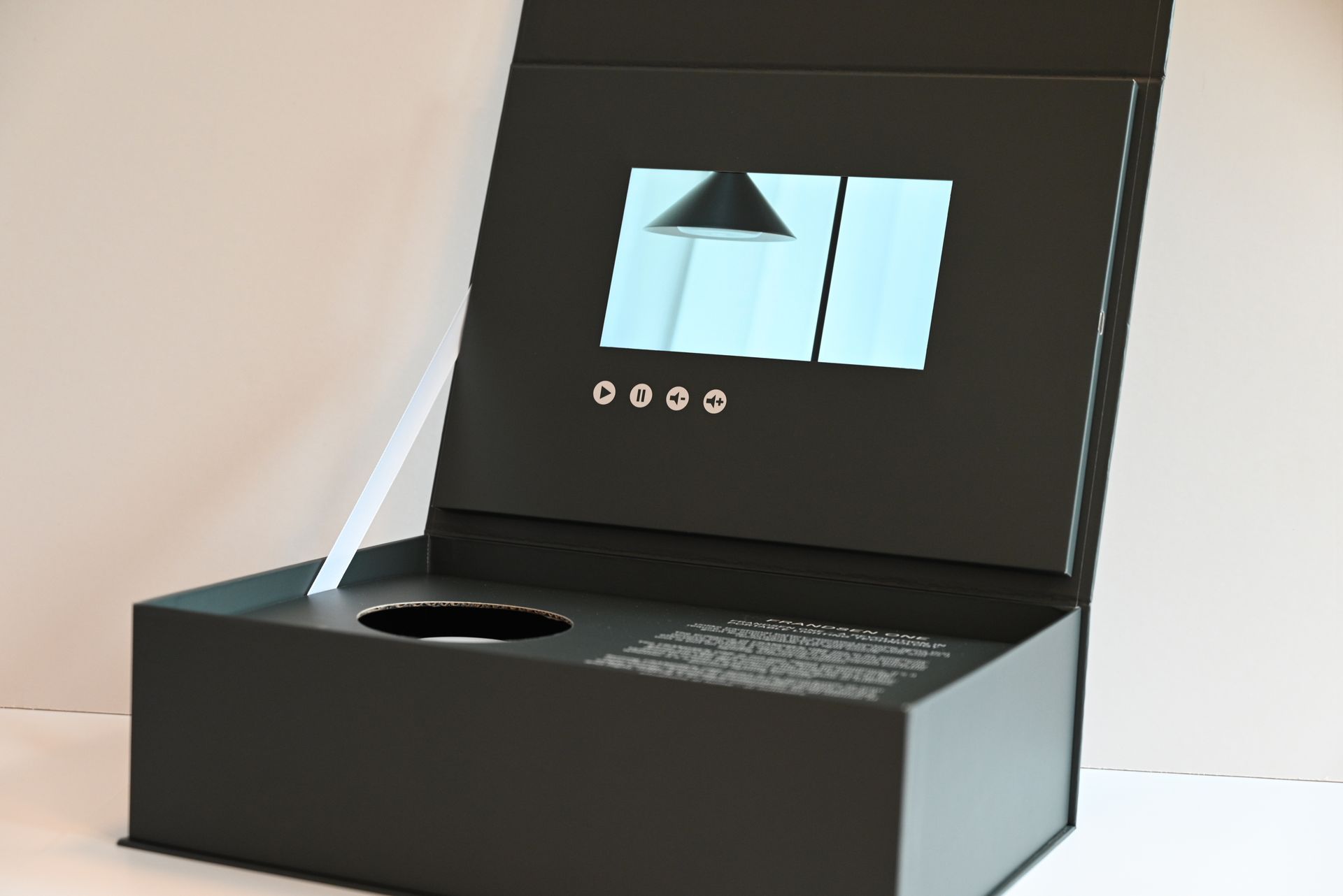 Sort præsentationsæske med pop-up-display og en cirkulær udskæring i bunden