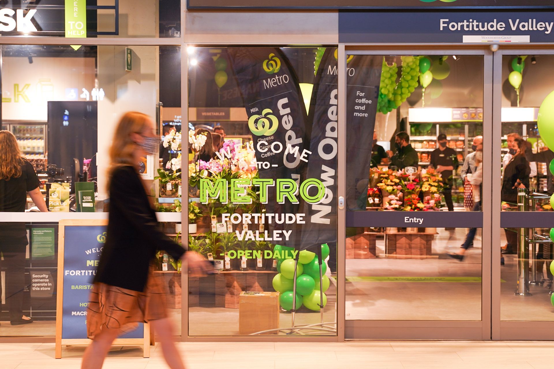 A woman is walking in front of a metro fortitude valley store.