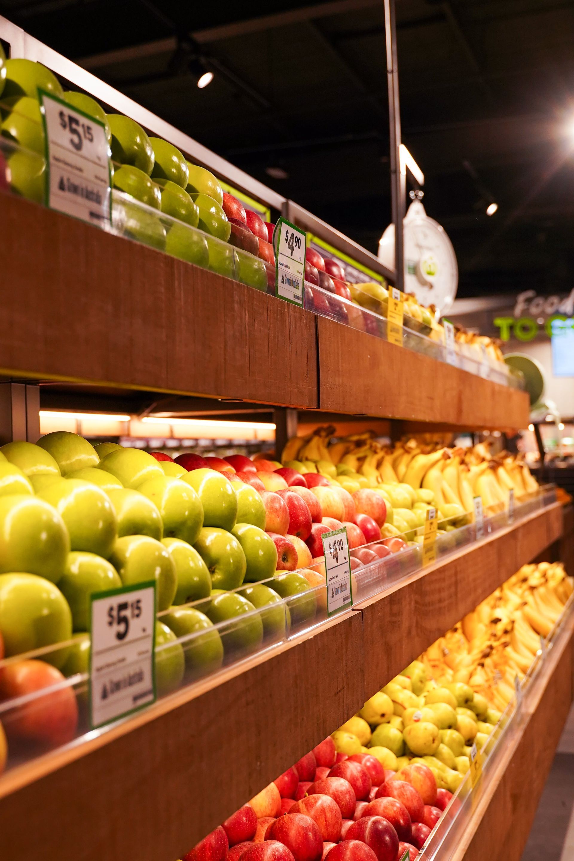 A variety of fruits and vegetables are on display in a grocery store.