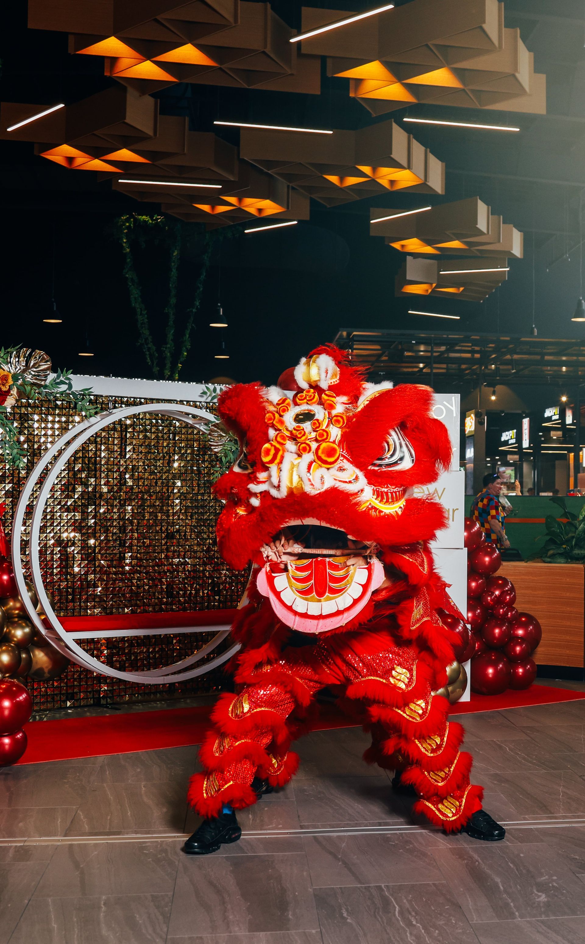 A person in a lion costume is dancing in a room.